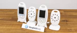 Babyfone verschiedener Marken in einer Reihe auf einem Holztisch.