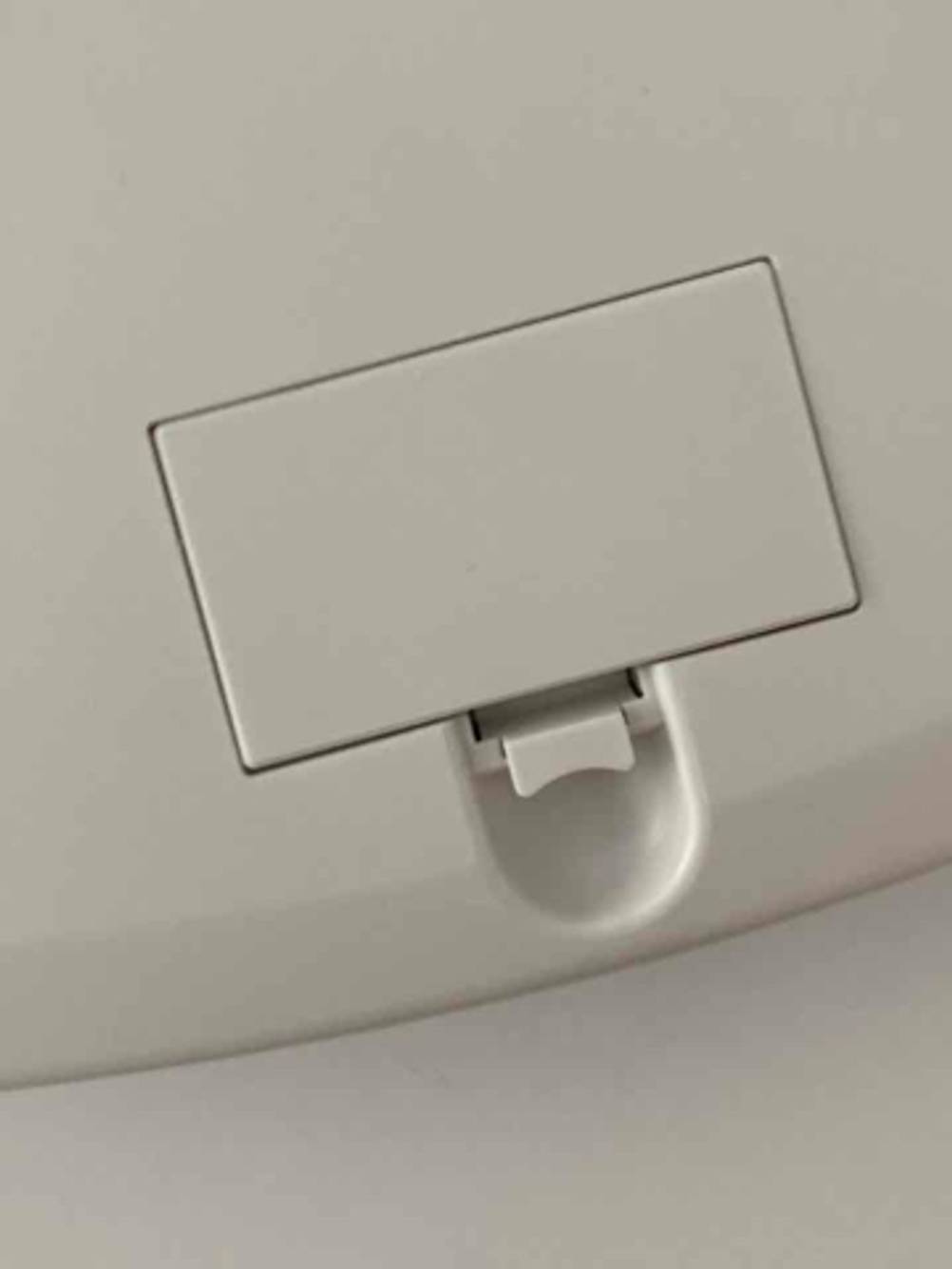 Detailansicht des Batteriefachs auf der Unterseite einer weißen Babywaage im Test.