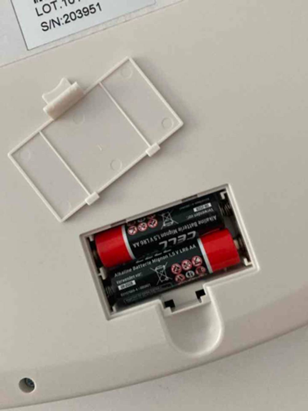 Nahaufnahme des geöffneten Batteriefachs, inklusive zweier AA-Batterien, auf der Unterseite einer getesteten Babywaage.