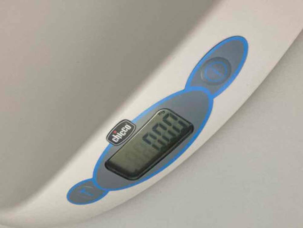 Detailansicht des digitalen Displays zwischen den Einschalttasten, auf einer weißen Babywaage im Test der Marke chicco.