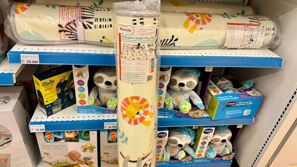 Krabbelmatte getestet: Nahaufnahme des Labels auf der verpackten Matte, im Hintergrund ein Verkaufsregal.