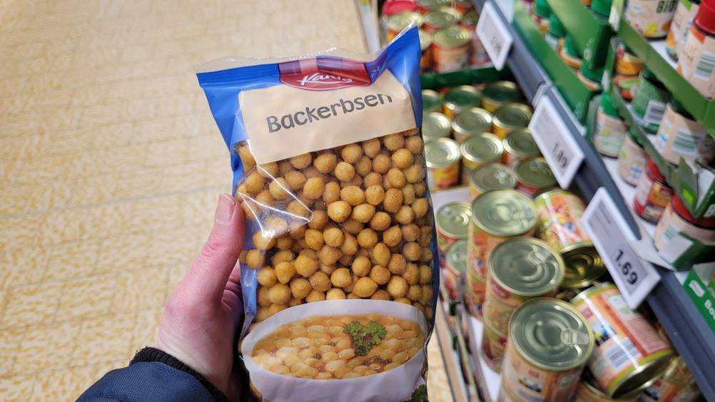 Eine Hand hält eine Packung Backerbsen im Test hoch.