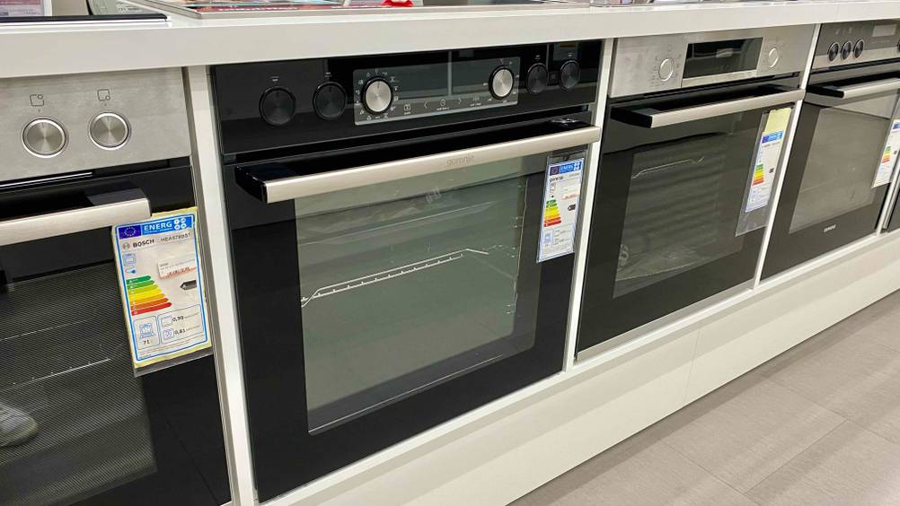 Ein getesteter Backofen 300 Grad zwischen anderen Geräten in einer Ausstellung.