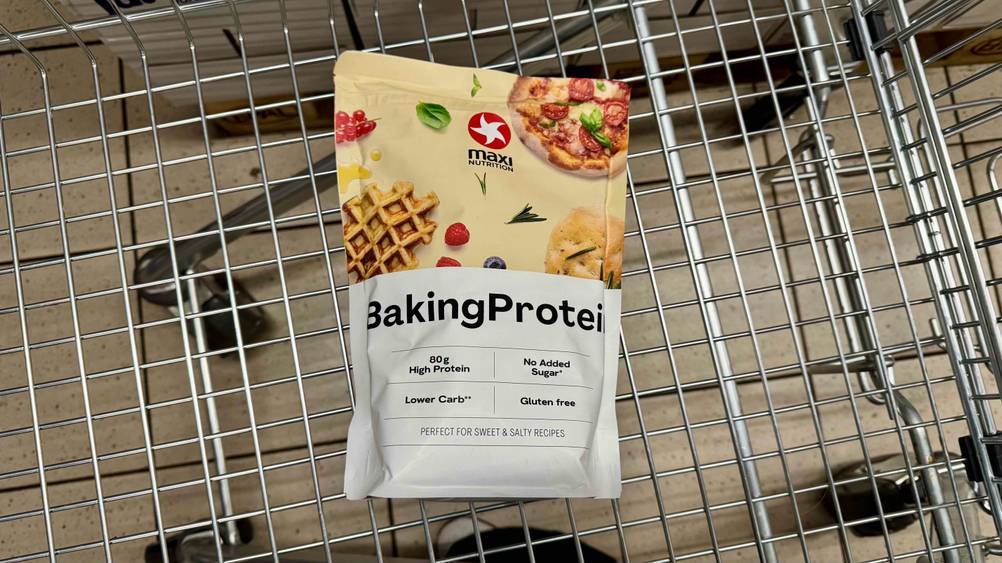 In einem Einkaufswagen liegt eine Packung des getesteten Backproteins.