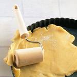 Nudelholz-Test: Nahaufnahme einer Backrolle und eines Teiges in einer Kuchenform. 