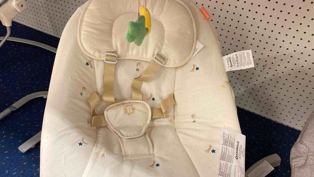 Detailansicht des beigefarbenen Bezuges inklusive Gurtsystem einer Badabulle Babyschaukel im Test.