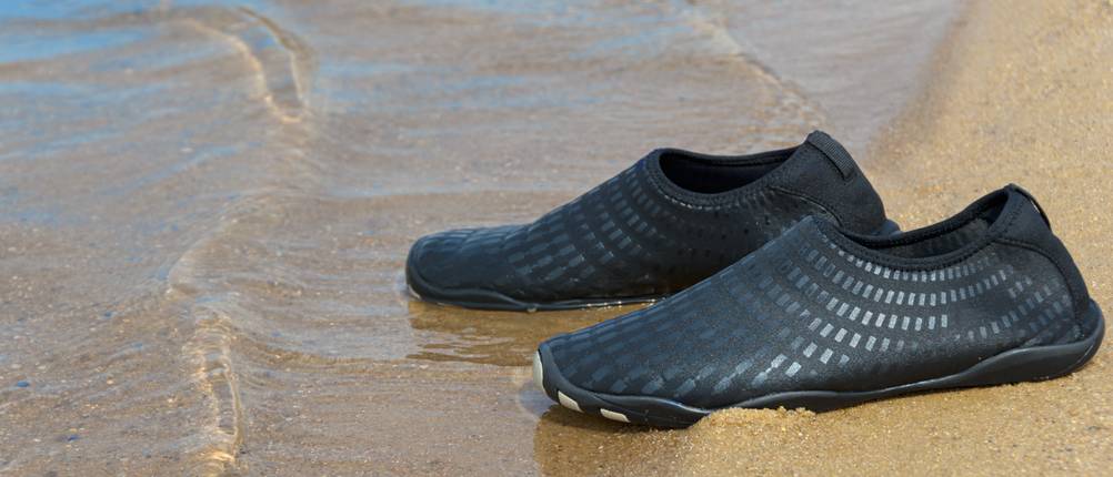 Badeschuhe für Erwachsene im Test: ein paar Badeschuhe am Ufer