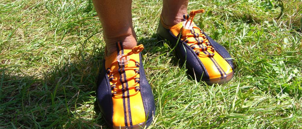 Badeschuhe für Erwachsene im Test: ein paar angezogene Badeschuhe auf einer grünen Rasenfläche