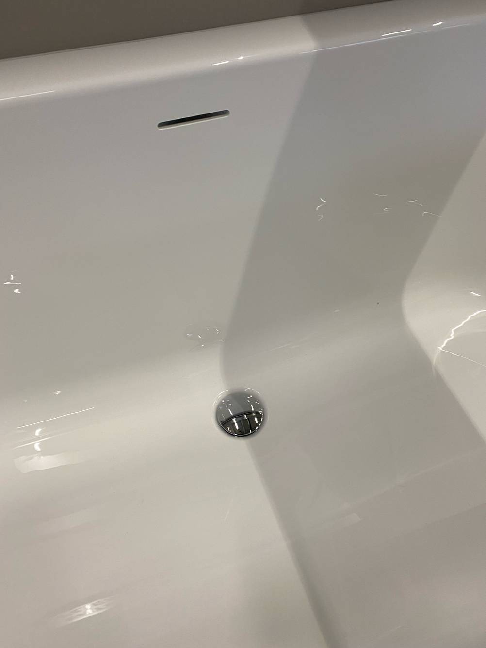 Detailansicht mit unterem und oberem Ablauf einer weißen getesteten Duschbadewanne.