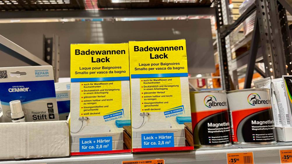 Zwei Packungen des Badewannenlacks im Test nebeneinander in einem Regal mit anderen Prokukten.
