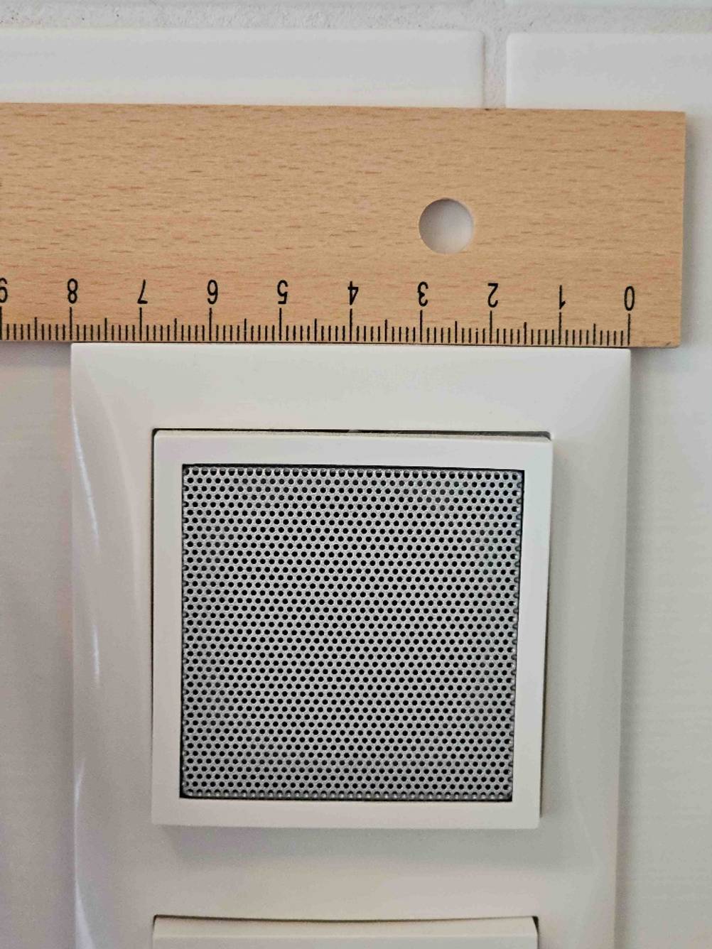 Nahaufnahme des Lautsprechers eines getesteten Badradios mit einem Lineal für die Größenverhältnisse.