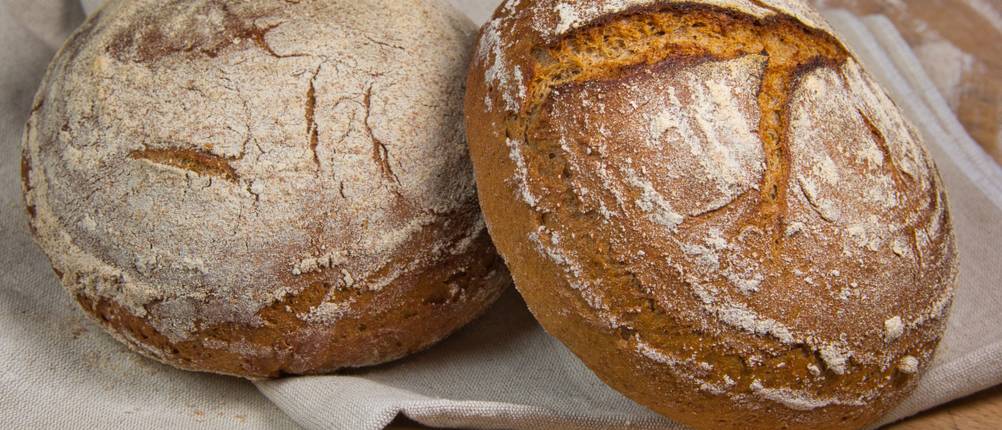 Bäckerleinen-Test: Zwei knusprig gebackene Laibe Brot auf Bäckerleinen. 