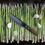 Bäckermesser-Test: Bäckermesser aus Kohlenstoffstahl liegt auf grünem Spargel