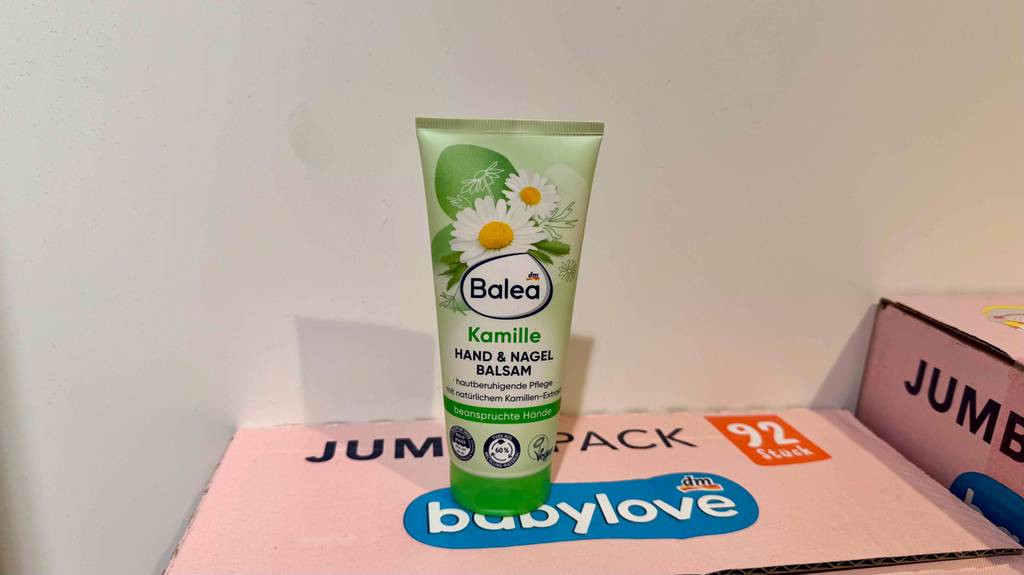 Im Test: Kamill-Handcreme in einer grünen Tube von Balea steht auf einem pinkfarbenen Karton.
