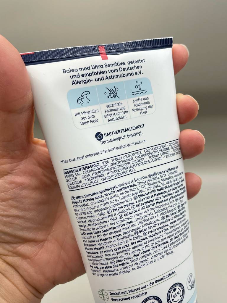 Duschgel für Neurodermitis-Test: Eine Hand hält eine Tube und zeigt die bebilderte Rückseite.