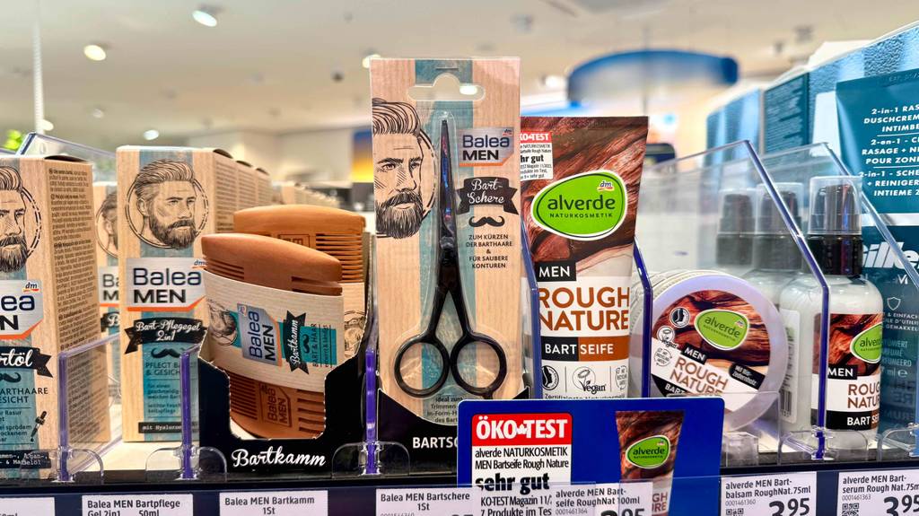 Bartschere im Test: Eine verpackte Schere steht zwischen anderen Bartpflegeprodukten in einem Regal.