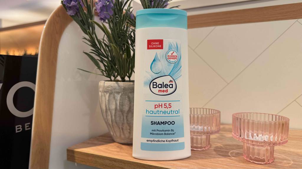 PH-neutrales Shampoo im Test: Eine Quetschflasche der Marke Balea steht auf einem Holzregal.