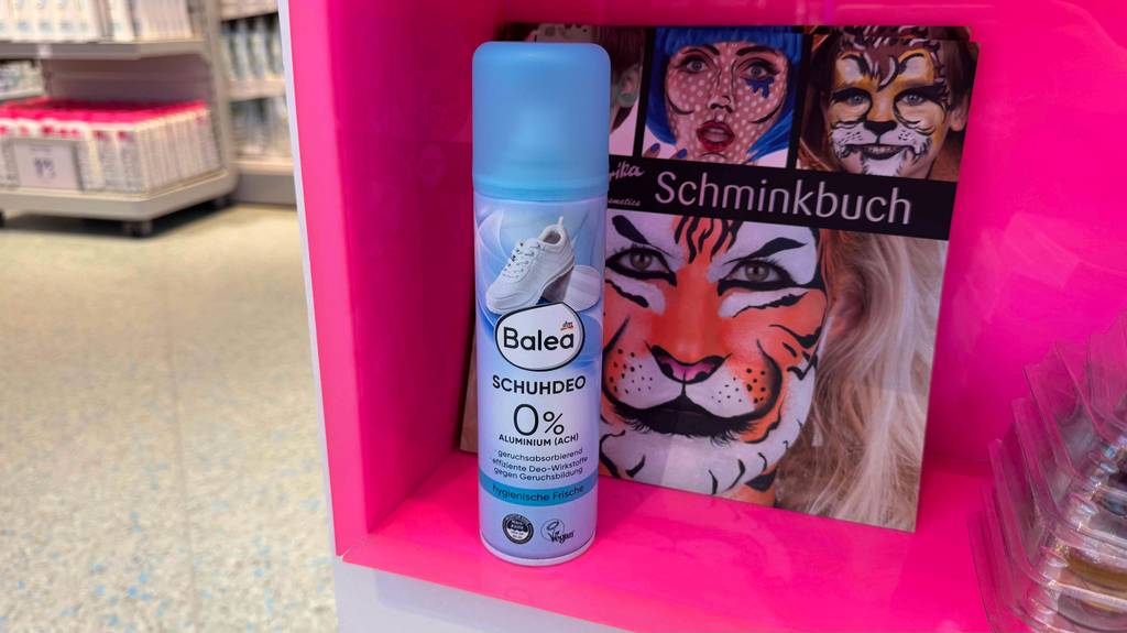 Schuhdeo-Test: Eine Spraydose von Balea steht vor einem Schminkbuch.