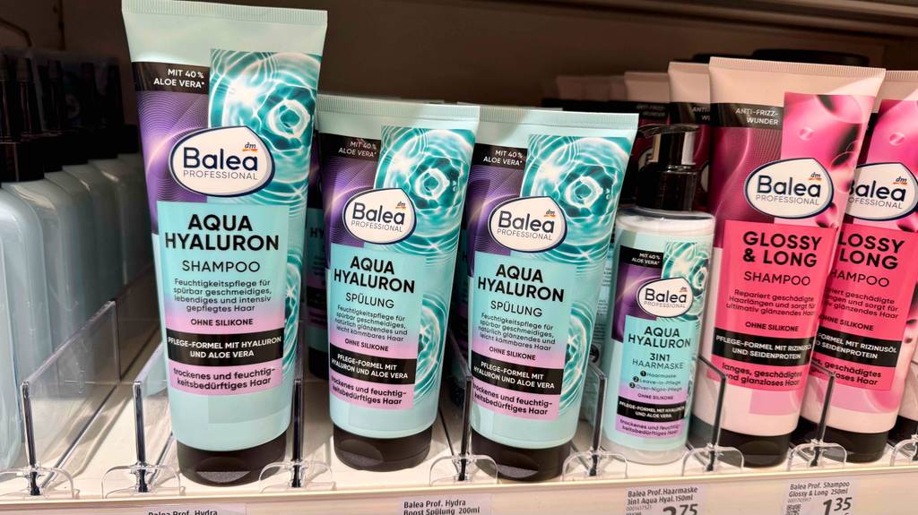 Balea-Spülung im Test: Mehrere Tuben stehen zwischen anderen Haarpflegeprodukten in einem Regal.