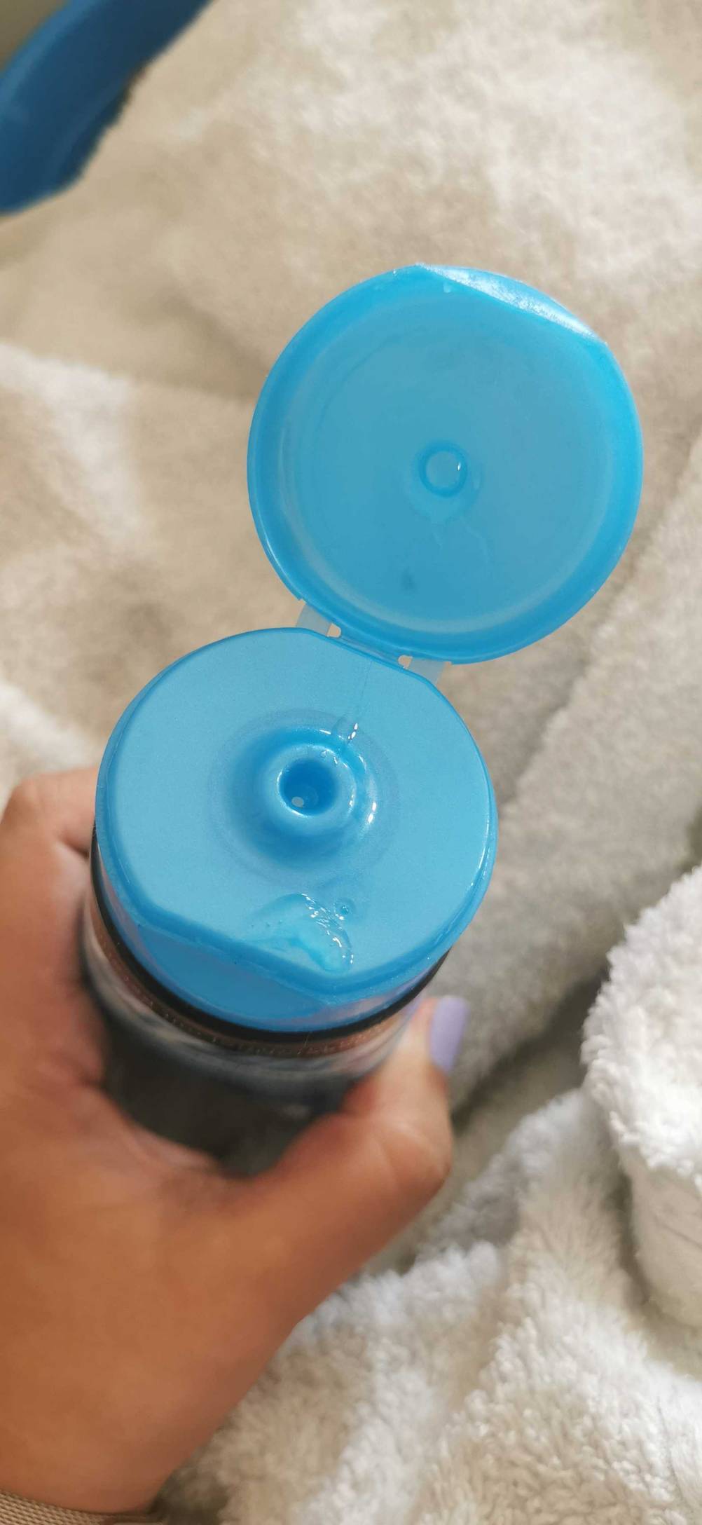 Tiefenreinigungsshampoo im Test: Hand hält eine geöffnete Tube mit der Öffnung nach oben.