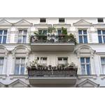 Außenfassade eines weißen Altbaugebäudes mit zwei Balkonen.