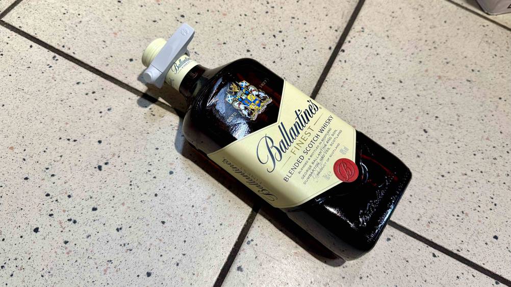 Ballantine’s Whisky im Test: Eine Flasche liegt horizontal auf eine Fließenboden.