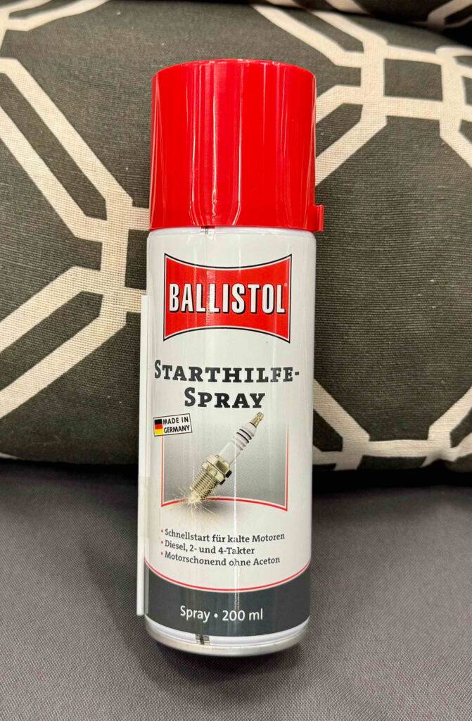Ein getestetes Starthilfespray in der Sprühdose steht auf dem Sofa.