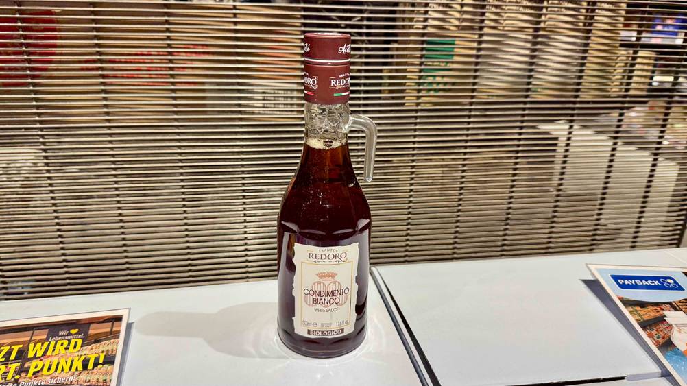 Auf einem hellen Regal steht eine Flasche des Balsamico bianco im Test.
