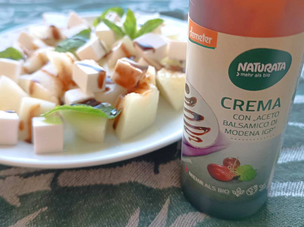 Im Test: Nahaufnahme des Labels einer Flasche Balsamico-Creme, im Hintergrund eine Teller mit Essen.