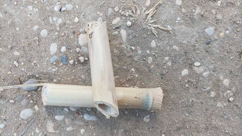 Im Test: Zwei Bambusröhrchen liegen überkreuzt auf einem Sandboden.