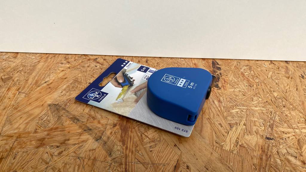 Bandmaß-Test: Bandmaß liegt in der Verpackung auf Holzuntergrund.
