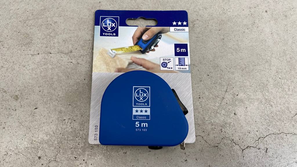 Bandmaß im Test: Bandmaß in Verpackung liegt auf Betonboden.