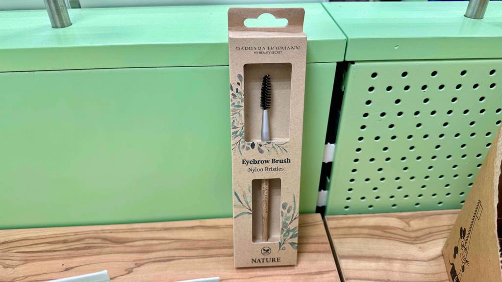 Nahansicht eines getesteten Augenbrauenpinsels in transparenter Kartonverpackung.