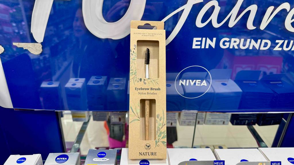 Im Test: Ein Augenbrauenpinsel steht in Verpackung auf anderen Pflegeprodukten.