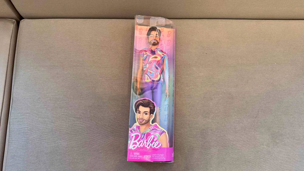 Ein getesteter Barbie-Ken in Originalverpackung auf einem Polster liegend.
