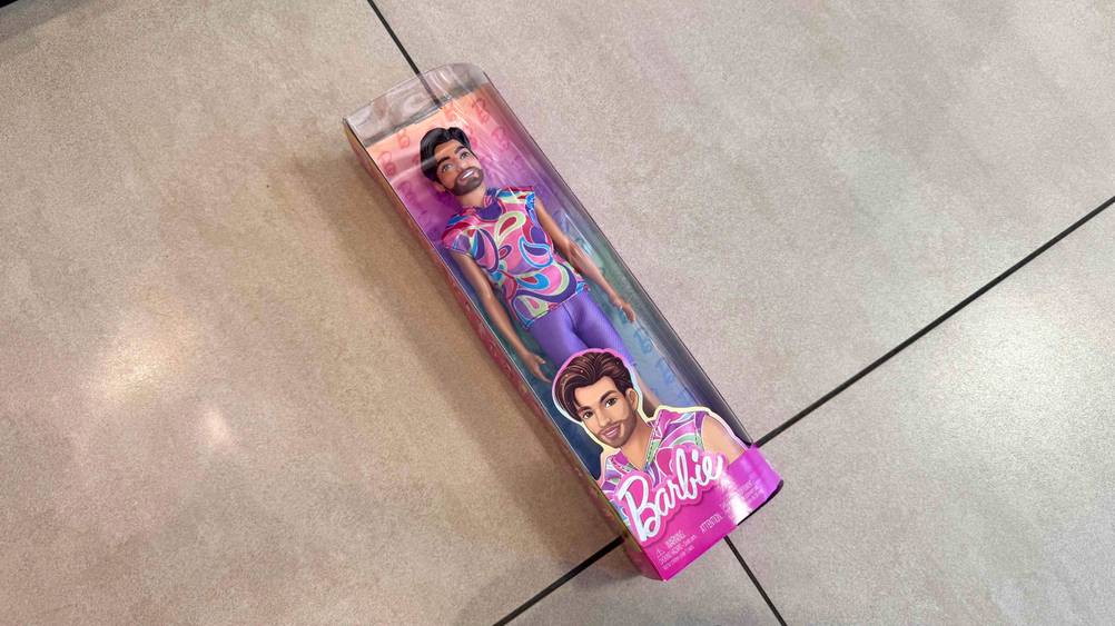 Auf einem Fließenboden befindet sich der Barbie-Ken im Test in der Verpackung.
