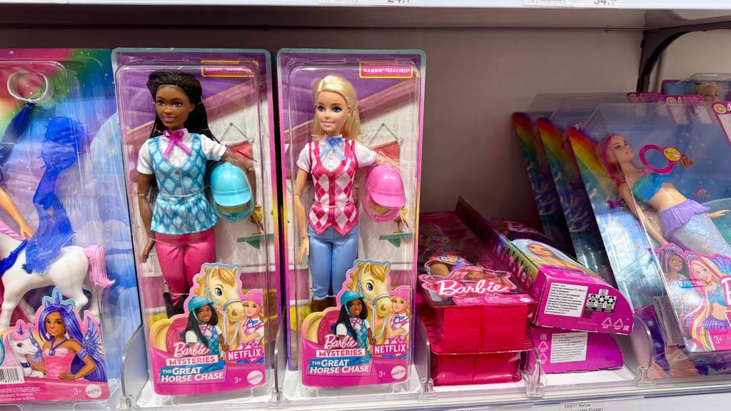 Barbie-Puppe im Test: Mehrere verpackte Puppen in unterschiedlichen Ausführungen stehen und liegen in einem Regal.