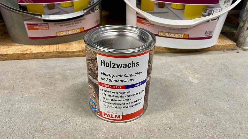 Eine Dose Palm Holzwachs steht zum testen auf einem Steinboden.