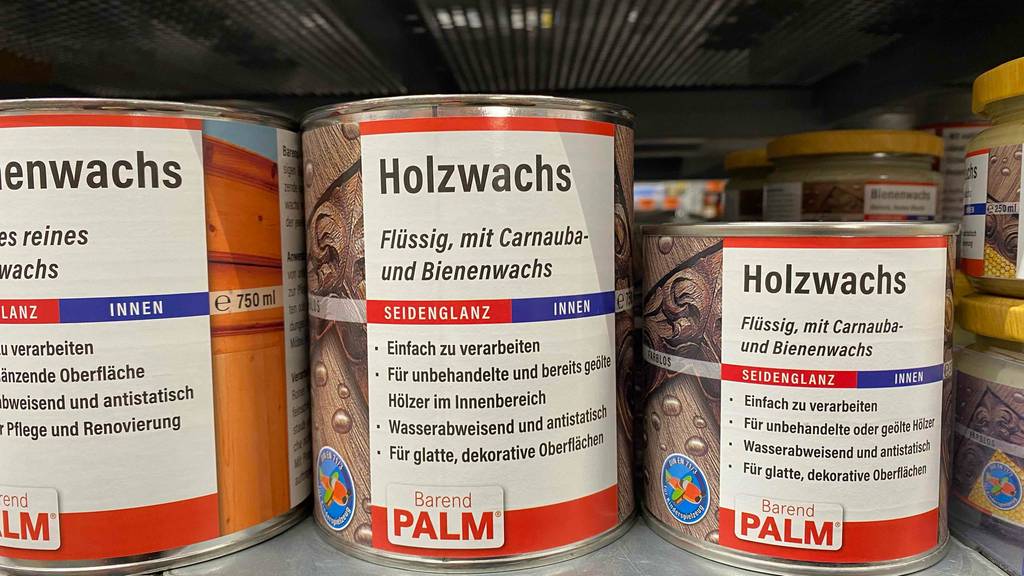 Im Test: Mehrere Dosen Holzwachs stehen in verschiedenen Ausführungen neben- und hintereinander in einem Regal.