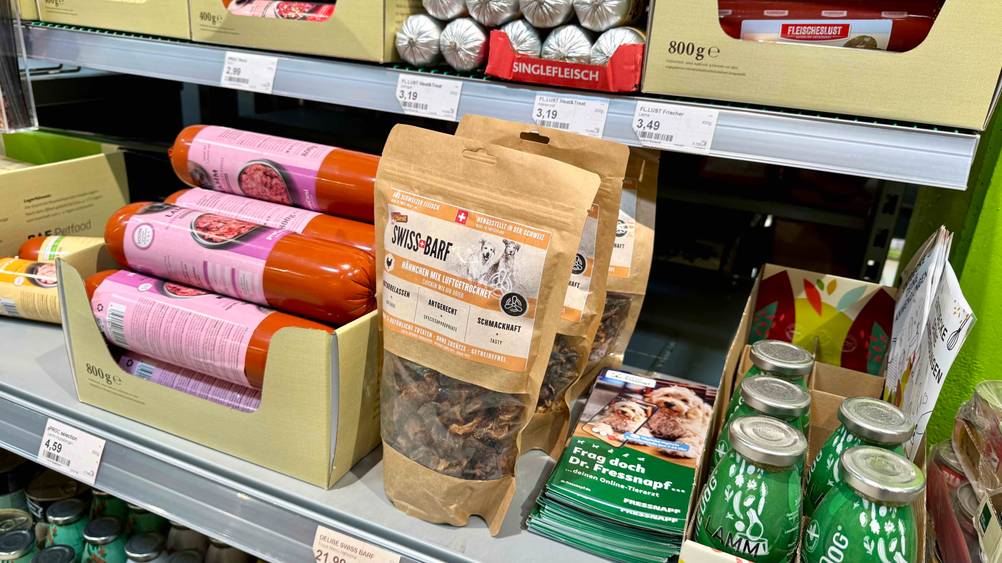 Mehrere Packungen des BARF-Hundefutters im Test in eine Verkaufsregal neben anderen Produkten.