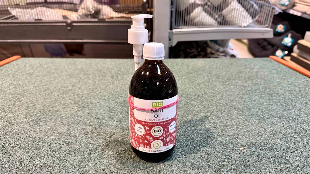 Barf-Öl getestet: Eine Flasche steht auf einem grauen Teppich.