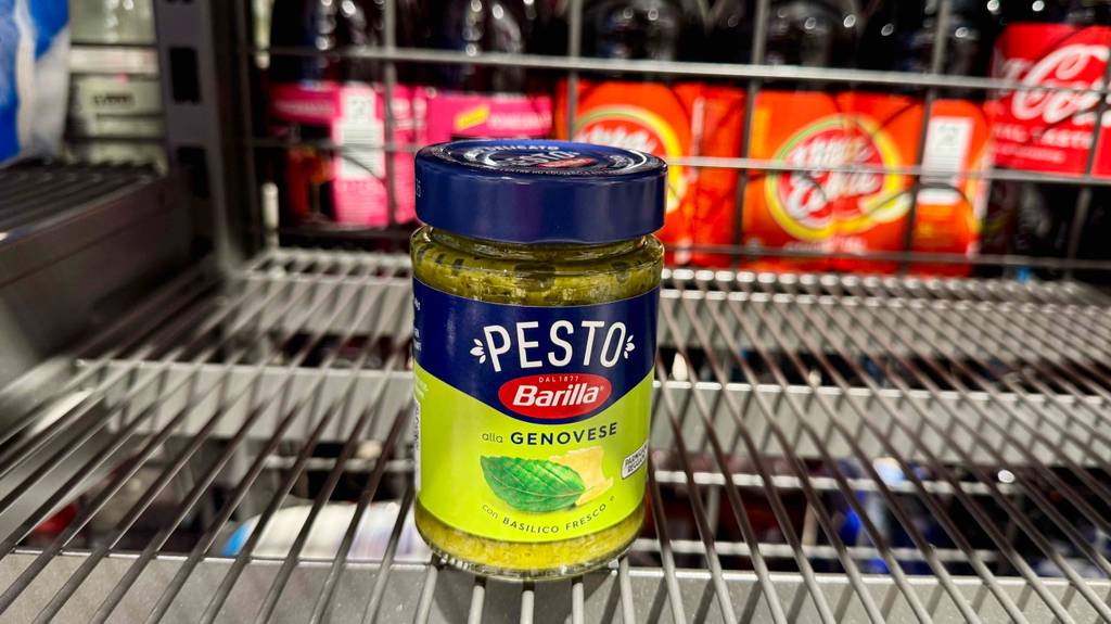 Auf dem Glas eines getesteten Pesto Genovese ist ein großes Basilikumblatt.