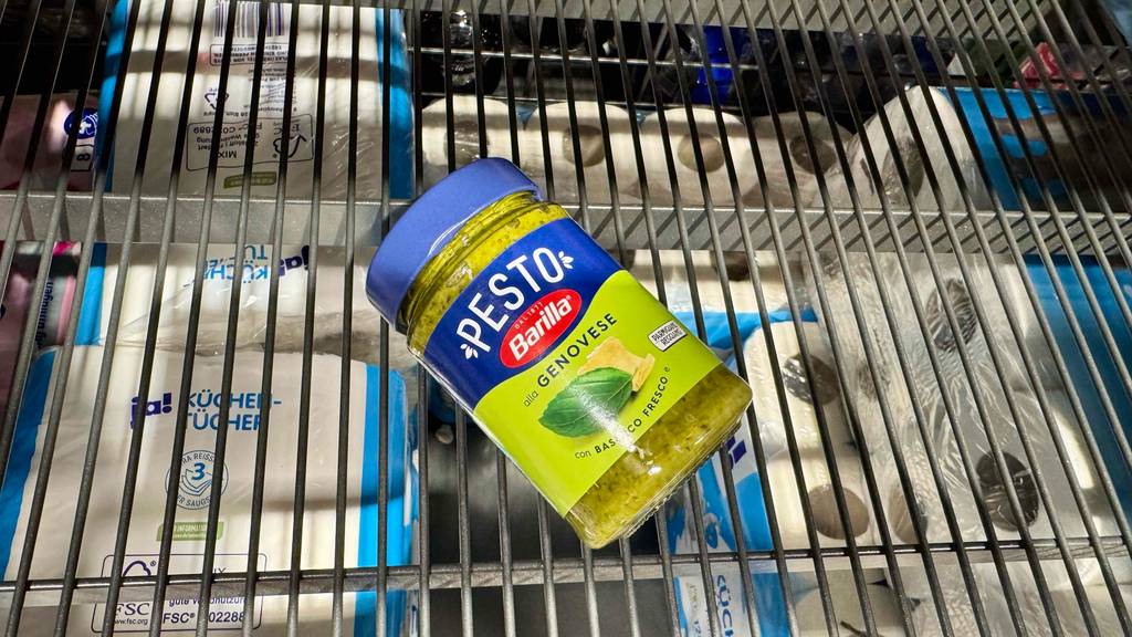 Ein Glas getestetes Pesto Genovese liegt auf einem Gitterregal.