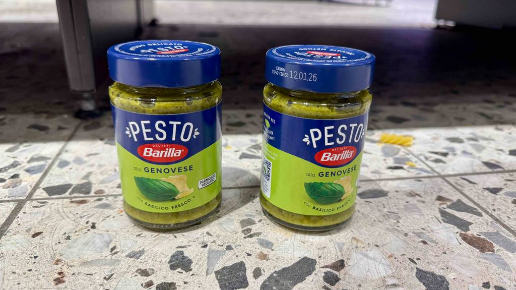 Zwei Gläser Pesto Genovese im Test stehen nebeneinander auf gesprenkelten Fliesen.