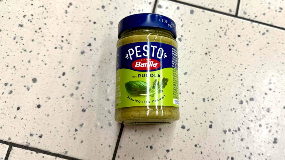 Auf einem hellen Boden liegt ein Glas des Barilla-Pestos im Test.