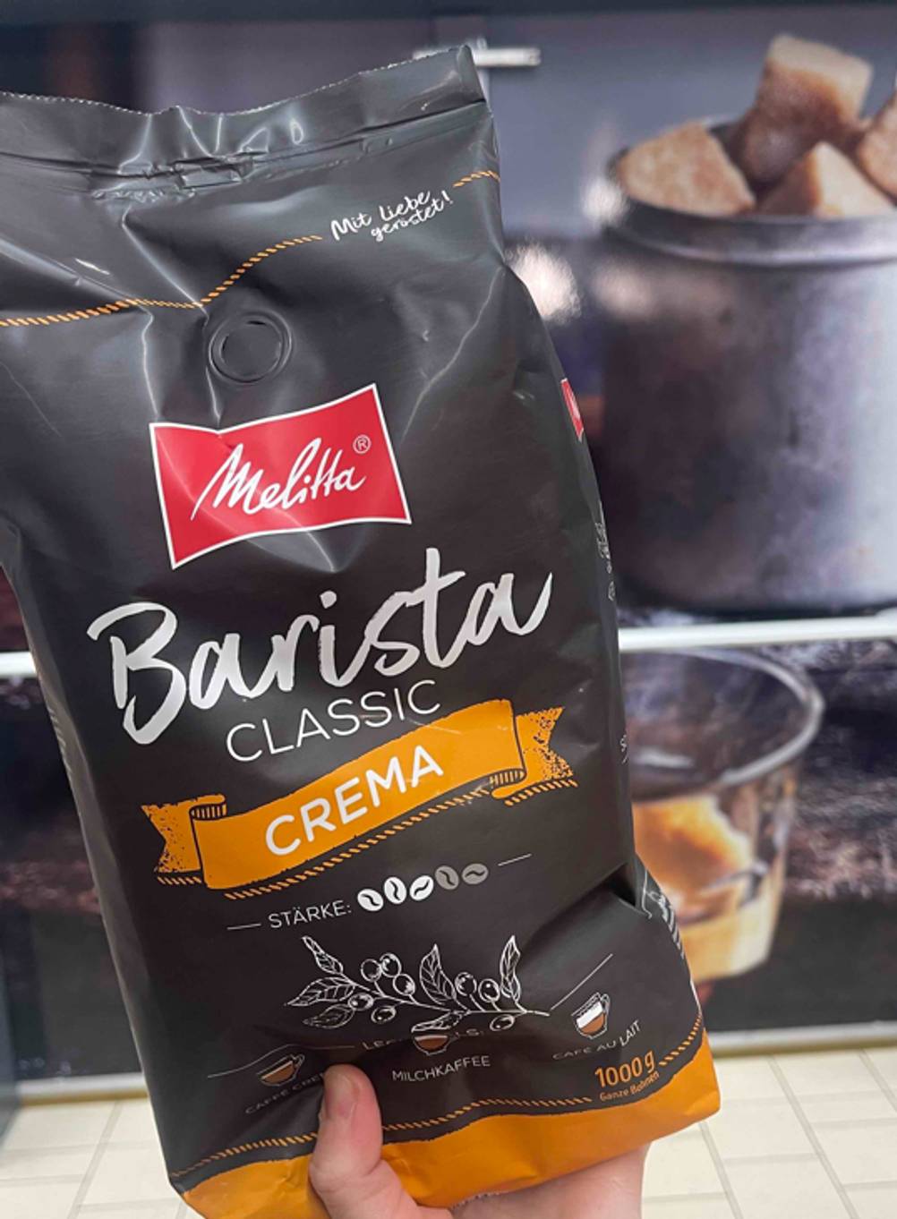 Im Test: Eine Hand hält eine Packung Barista-Kaffeebohnen der Sorte Crema.