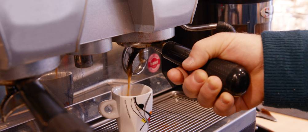 Bartscher-Kaffeemaschine-Test: Person bereitet einen Espresso an einem Kaffeevollautomaten zu.