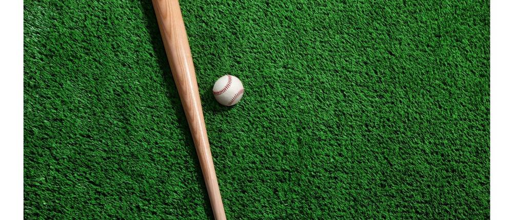 Baseballschläger im Test: Ein Baseballschläger und ein Baseball liegen auf Gras