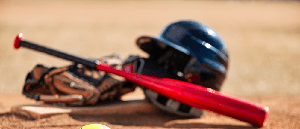 Baseballschläger im Test: Ein Baseballschläger und Ausrüstung liegen auf einem Spielfeld