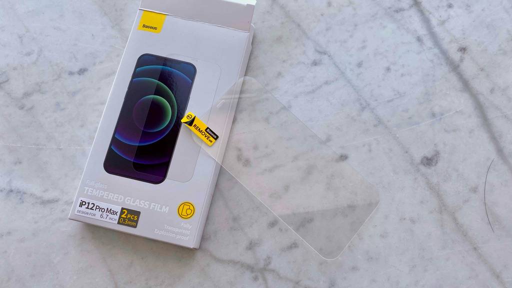 Ein Iphone-12-Pro-Max-Panzerglas liegt halb quer zum testen auf der Originalverpackung.